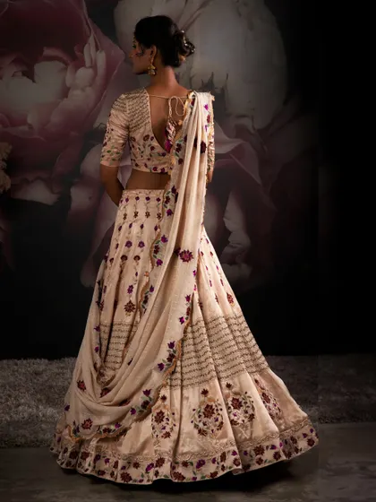 The back of a bridal lehenga is just as important as the front. This view showcases the delicate draping and deep back design, complete with traditional tassels, ensuring elegance from every angle.