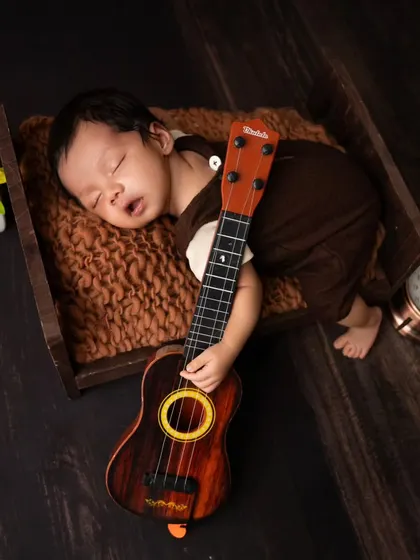 A close-up portrait of a sleeping newborn with his ukulele. I focus on capturing their peaceful expressions and tiny features during these sessions.