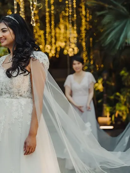 A magical moment with the bridesmaids. The bride shares a laugh with her girls under a canopy of fairy lights, their smiles illuminating the evening.