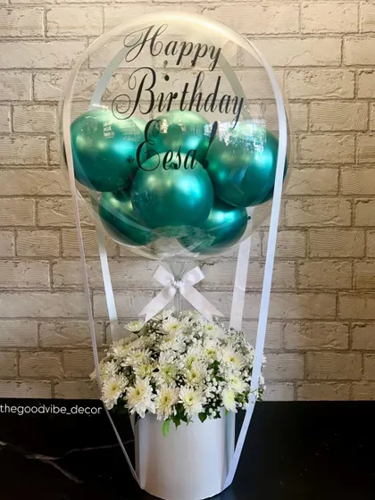 A beautiful birthday Bobo Box created for Eesa. This piece combines fresh white chrysanthemums with shiny teal balloons inside a personalized clear bubble, all set in a clean white box.