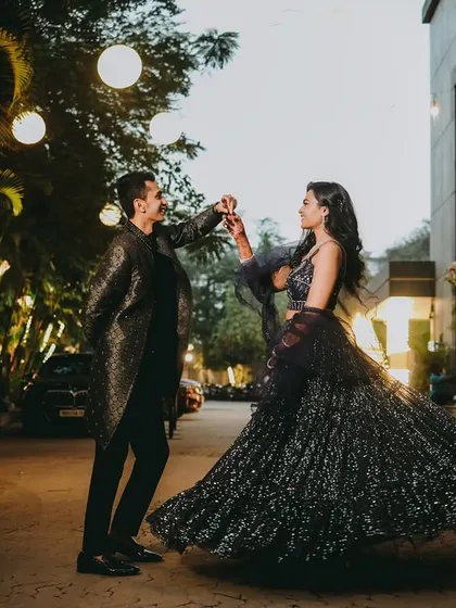 A glamorous twirl under the soft glow of evening lights. The bride's sparkling lehenga comes to life in this dynamic shot, perfect for a chic, modern engagement celebration with a touch of cinematic flair.