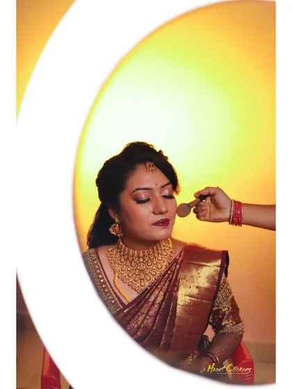 A creative "getting ready" shot of the bride, framed by a ring light as her makeup is applied.