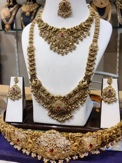 A beautiful antique-finish bridal set with a ruby-studded choker, haram, and an intricately designed vaddanam.