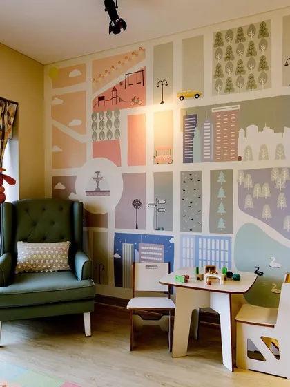 Every room needs a dedicated play corner. Here, a child-sized table and chairs are set against a beautiful, custom-designed city map wallpaper, creating an inspiring spot for creative activities.