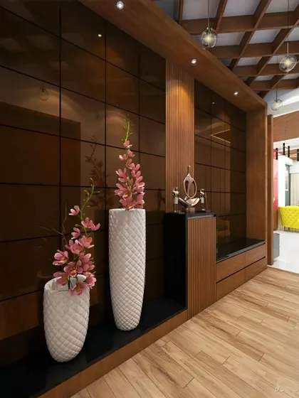 A sophisticated entryway with dark reflective wall panels and a wooden ceiling. The long, low bench and integrated shelving provide a sleek and minimalist storage and seating solution.