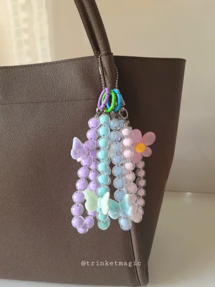Why have one charm when you can have a cluster? This multi-strand beaded charm features pastel butterflies and a flower, creating a beautiful cascading effect on a tote bag.