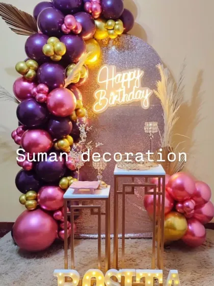 A chic birthday party with a rose gold sequin backdrop and a balloon garland in purple, pink, and gold.