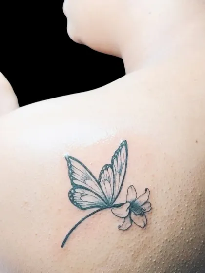 A dragonfly tattoo on the shoulder blade.