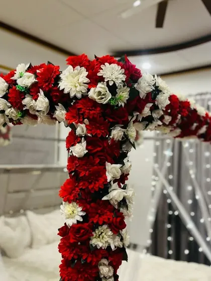 Another detail shot of the floral canopy over the bed, showing the texture and richness of the red and white flower combination.