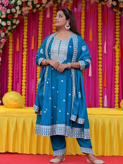 A full-length pose in the beautiful turquoise Anarkali. The outfit's flow and design are perfect for a host who is always on the move.