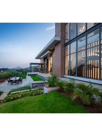 This is a duplicate of ID 82. The landscaped patio of the Nandi Hills home provides a seamless transition from the living area to the garden.
