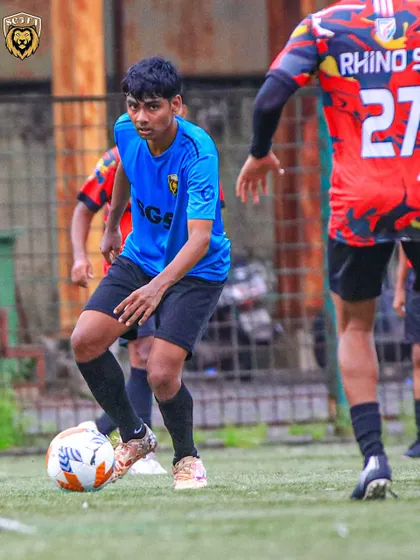 A player in our blue kit controlling the ball during a First Division match, looking to create an opportunity.