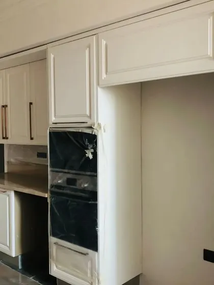A close-up of the white kitchen cabinetry, showing the built-in oven unit and classic door profiles. This demonstrates our attention to detail in creating timeless kitchen designs.