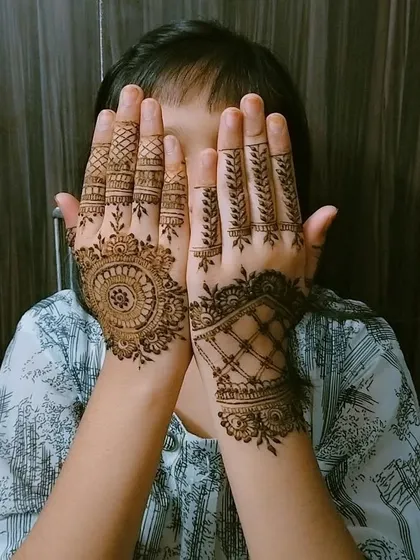 A cute and shy pose from a young client showing off her new henna. I can create a variety of designs that kids love, from simple mandalas to delicate finger patterns.