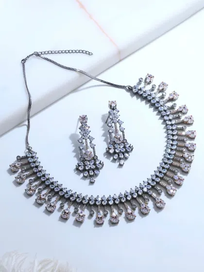 A flat lay of the black rhodium necklace and earrings. This view highlights the contrast between the sparkling fancy-cut diamonds and the dark, modern finish of the rhodium.