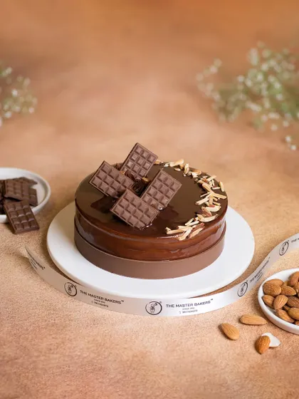 This Chocolate Almond cake is all about texture. A rich chocolate cake is covered in a glossy ganache and topped with crunchy almond slivers and decorative chocolate bars.