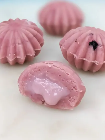 The Blueberry Cake Mithai offers a burst of fruity flavor, with a sweet and tangy blueberry filling encased in a beautiful shell-shaped sweet.