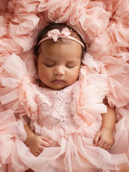 Look at this little princess! I have a collection of beautiful, soft outfits and props, like this delicate pink lace romper and ruffled backdrop, to make your baby girl's first portraits absolutely magical.