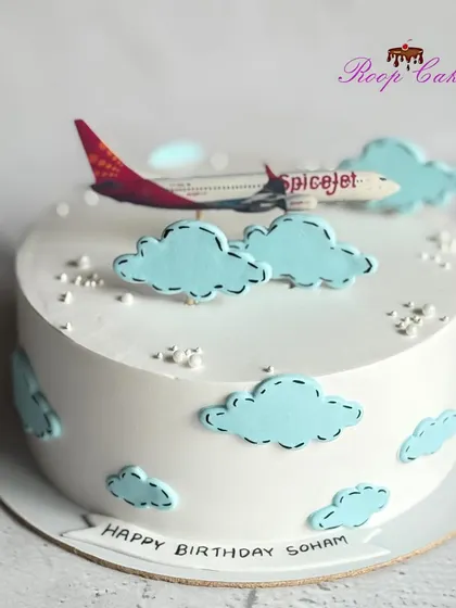 A half-kg cake for an aviation enthusiast, featuring a SpiceJet airplane flying through fluffy clouds.