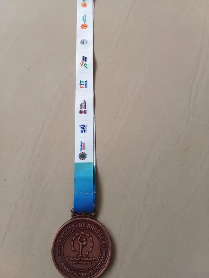 The full medal and lanyard from the Yogasana Bharat national competition. Every detail represents a step on the long journey of a competitive athlete.
