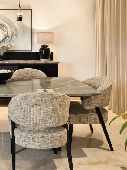 The dining area at Terra, where monochromatic themes create a cohesive and refined atmosphere. The interplay of materials, from the textured chairs to the smooth marble tabletop, brings character while maintaining a balanced design.
