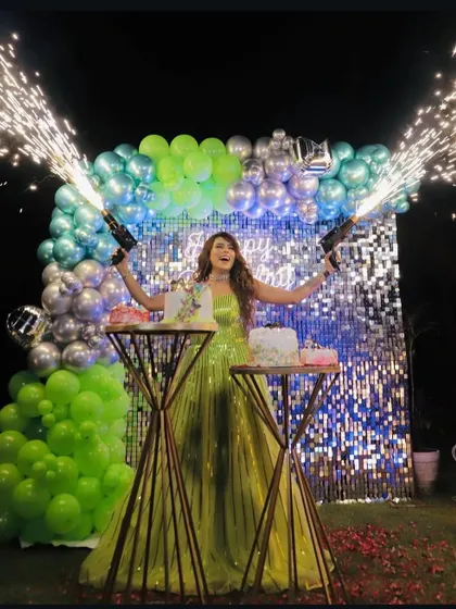 I also do birthdays. Here, the birthday girl celebrates with handheld cold pyro guns in front of a sequin and balloon backdrop, adding a fun and safe pyrotechnic element to the cake cutting ceremony.