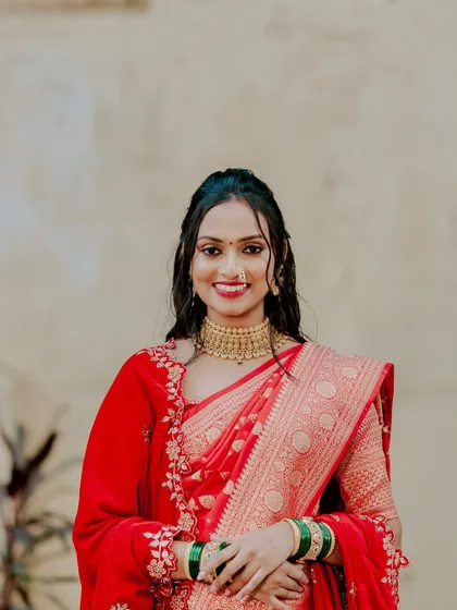 A beautiful portrait of the bride. Her smile is the best accessory, enhanced by a clean makeup look with a classic red lip and defined eyes.