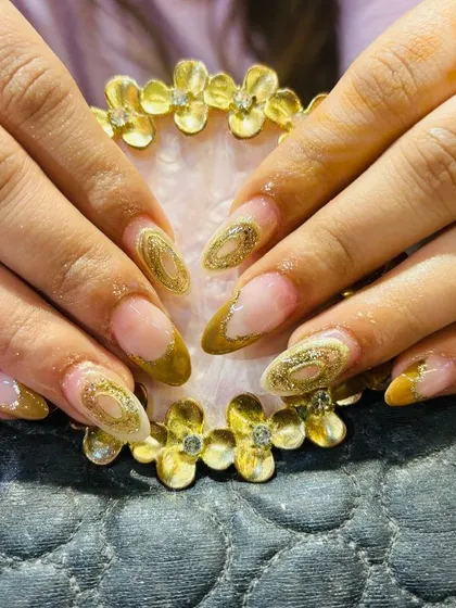 An intricate design with a gold glitter outline creating a "geode" or "cutout" effect on the nail.