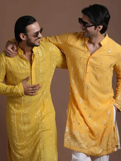 Brothers or friends can coordinate in style. This image shows two different yet complementary yellow kurtas, perfect for a unified look at a wedding event.