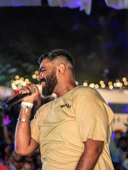A profile shot of me on the mic, smiling as I interact with the crowd at an outdoor festival.