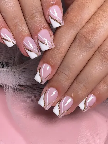 A classic square-tipped French manicure with a twist. This design features an elegant gold glitter swirl separating the pink base from the white tip.