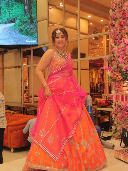 For my brother's wedding, I chose this vibrant orange and rani pink lehenga. It was the perfect balance of delicate mirror work, joyful color, and comfortable volume, allowing me to enjoy the festivities without feeling weighed down. This is what I aim for with all my clients: a look that is both stunning and practical.