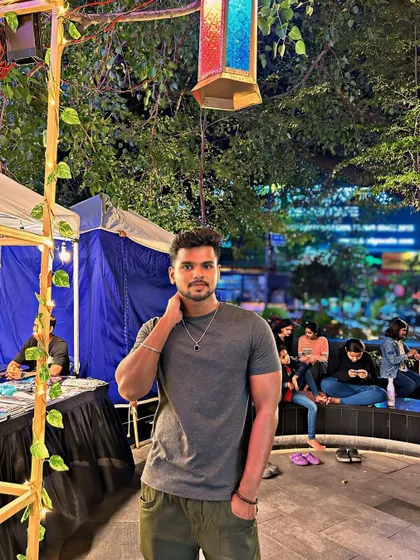 At a night market or festival in Bengaluru, surrounded by lights and crowds.