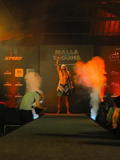 A wider shot of the fighter's entrance, showing the full scale of the event. We prepare our athletes for the big stage.
