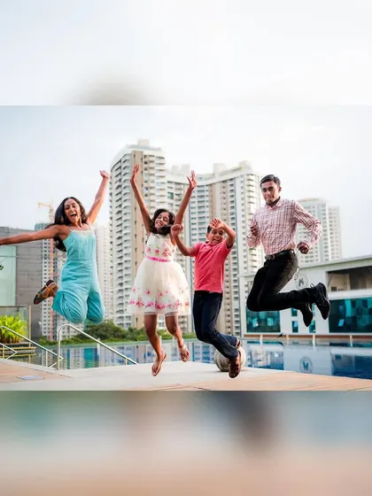A fun, energetic shot of a family jumping for joy by the pool. We encourage playful moments to bring out the natural happiness and connection in our family portraits.