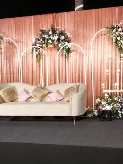 A direct view of the elegant reception stage, highlighting the symmetry of the design with its clean arches, balanced floral decor, and soft, ambient lighting.