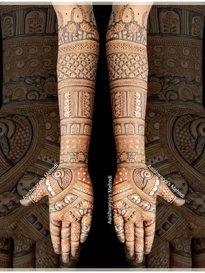 This is a very traditional and intricate bridal design, filled with fine lines and detailed patterns like peacocks and elephants, covering the hands and arms completely.