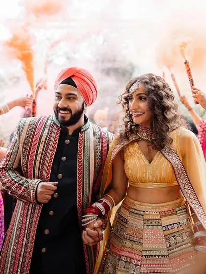 A vibrant entrance of a couple at their Punjabi wedding, complete with color smoke. We capture the high energy and festive spirit of North Indian weddings.