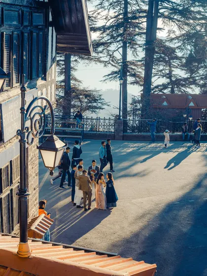 A sunny day on the Ridge in Shimla. The long shadows and bright light create a high-contrast scene full of life and energy.