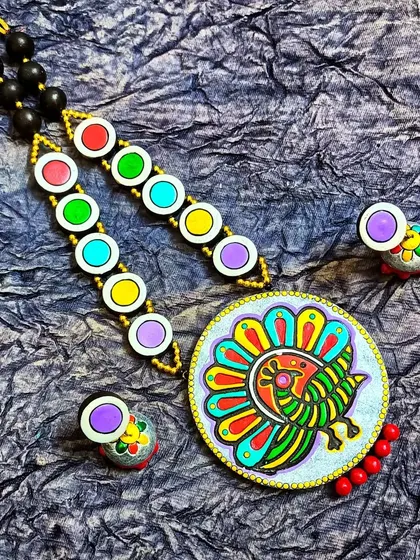 A vibrant, block-printed peacock necklace on a silver-grey base with a multi-colored beaded chain. This piece is a perfect example of my colorful and joyful design aesthetic.
