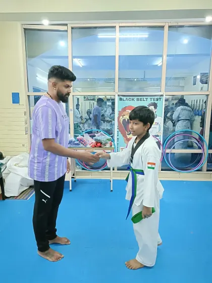 A student receives his green and blue belt.
