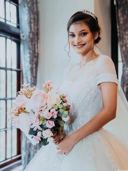 A classic bridal portrait by a window, using natural light to highlight the bride's features and her beautiful dress.