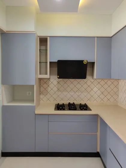 A detailed view of the cooking area, with the black chimney providing a strong visual contrast against the light-colored cabinets and backsplash.