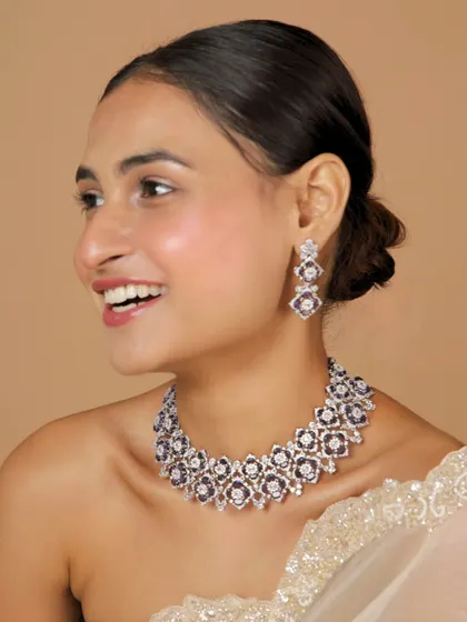 A smiling model wearing our new polki diamond collection. This set features deep purple stones, offering a unique and luxurious look.