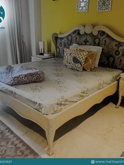 For those who love classic style, I craft beds with detailed carving and traditional silhouettes. This piece features an ornate headboard with a fabric insert, paired with matching carved side tables.