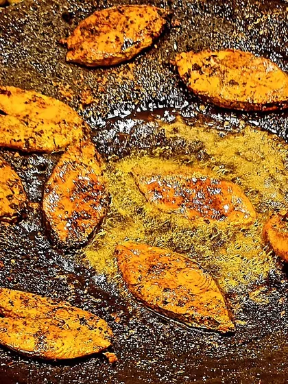Tandoori seer fish being fried on a large tawa. This is part of our traditional Kutchi Memon menu, offering a delicious seafood option for your event.