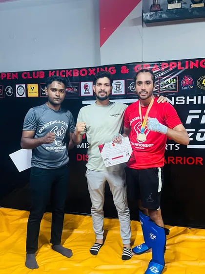 A student celebrates his first fight victory with his coaches. This is a huge milestone that is the result of months of dedicated training.