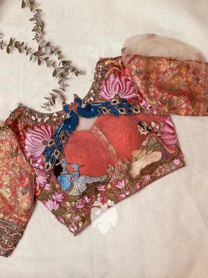 A breathtaking red brocade Muhurtham blouse inspired by the timeless love story of Radha and Krishna, with majestic peacock motifs on the back.