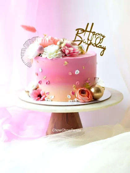 A side view of the pink ombre floral cake, showing the beautiful gradient and arrangement of flowers.