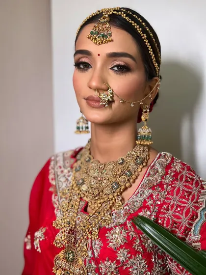 The bride looks stunning and regal with her traditional jewelry and classic hairstyle.